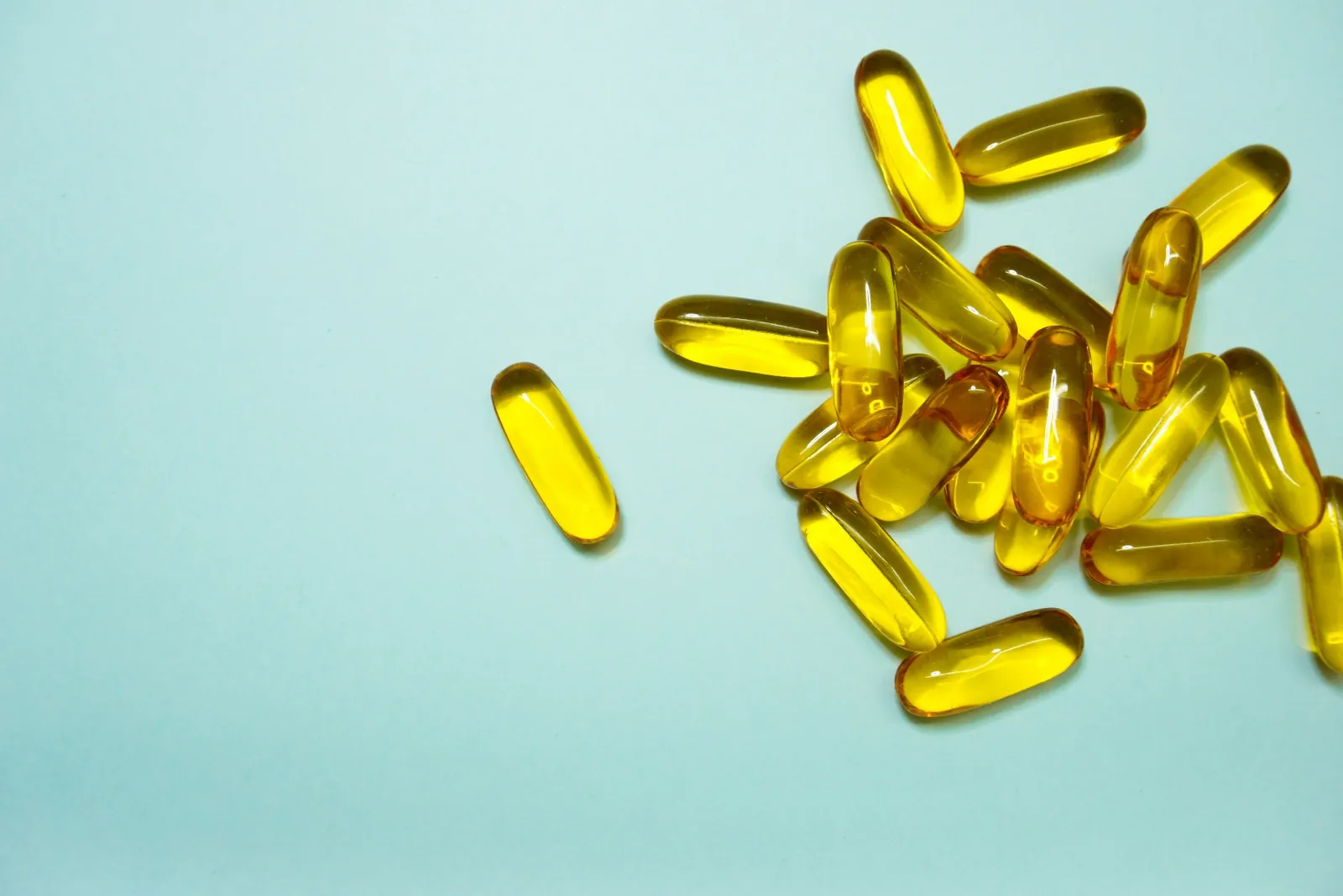 Omega-3 softgels arranged on a pale surface